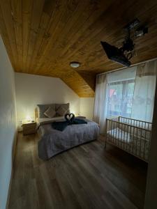 a bedroom with a bed and a wooden ceiling at Chata Fir in Martin