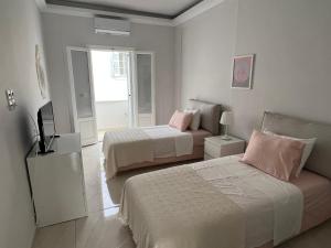 a bedroom with two beds and a television in it at Spetses maisonette 2 bedrooms for 6 persons. in Spetses