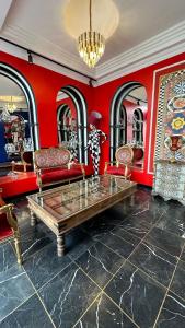 THINK HOTEL في كونيا: غرفة معيشة بجدران حمراء وطاولة وكراسي