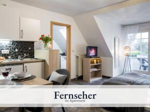 een keuken en een woonkamer met een tafel in een kamer bij Blumenvilla 6 mit Küche, Balkon, Sauna und Garten in Schneverdingen