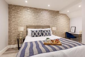 a bedroom with a bed with a tray of food on it at Sea Breeze - Pebbles in Bournemouth