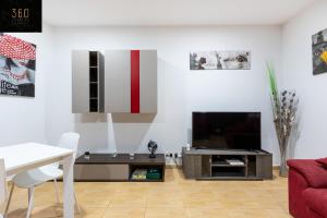 een woonkamer met een televisie en een tafel bij A Large house in central pieta with BBQ & Terrace by 360 Estates in Tal-Pietà