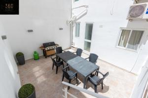 een patio met een tafel en stoelen en een grill bij A Large house in central pieta with BBQ & Terrace by 360 Estates in Tal-Pietà