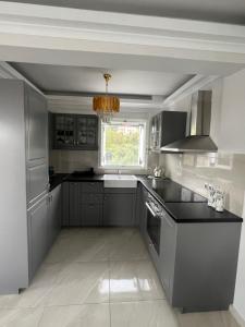 a kitchen with gray cabinets and a sink and a window at Spetses maisonette 2 bedrooms for 6 persons. in Spetses