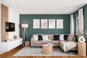 a living room with a couch and a green wall at Design Apartment 128qm mit Ausblick in Rettenberg