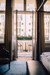 Schlafzimmer mit einer Tür, die auf einen Balkon führt in der Unterkunft Henri Hotel Berlin Kurfürstendamm in Berlin