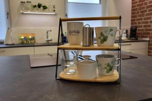 a shelf with four mugs on it in a kitchen at Ferienwohnung Domspitzen in Billerbeck