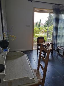 a room with a bed and two chairs and a window at La verdine in Arles