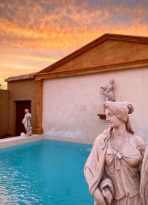 una statua di una donna accanto alla piscina di LA FUENTE ROMANA a Campo-Nubes