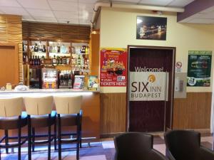 eine Bar in einem Restaurant mit Stühlen drum herum in der Unterkunft Six Inn Hotel Budapest in Budapest