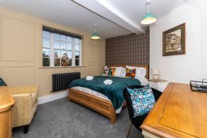 a bedroom with a bed and a table at The Clockhouse Bewdley in Bewdley