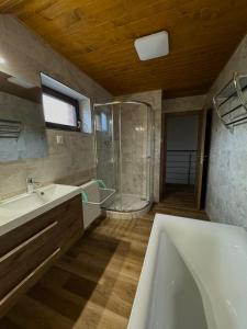 ein Bad mit einer Badewanne, einer Dusche und einem Waschbecken in der Unterkunft Chata Fir in Martin