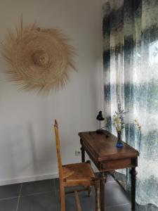 Habitación con mesa de madera y silla de madera. en La verdine, en Arles