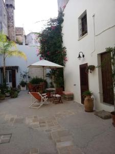 un patio con mesa, sillas y sombrilla en CASA FIORE, en Corigliano d'Otranto