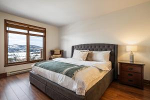 Un dormitorio con una cama grande y una ventana en Altitude 172-8/On Village with Astonishing VIEWS, en Mont-Tremblant