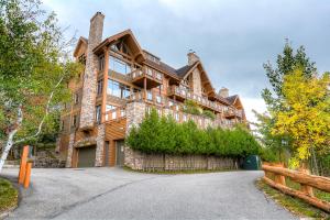 a large wooden house with a driveway at Altitude 172-8/On Village with Astonishing VIEWS in Mont-Tremblant