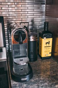 a blender sitting on a counter next to a bottle of whiskey at Altitude 172-8/On Village with Astonishing VIEWS in Mont-Tremblant