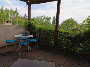 a patio with a table and chairs on a deck at La verdine in Arles