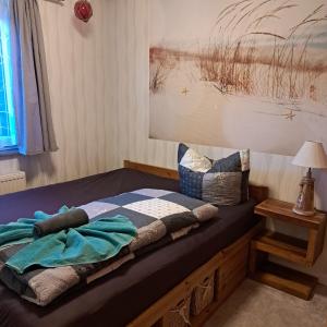 a bed with a blanket on it in a room at Fewo Seerose in Zempin