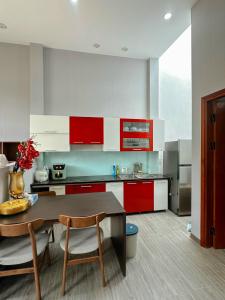 uma cozinha com armários vermelhos e brancos e uma mesa em Vũ Homestay em Cao Bang