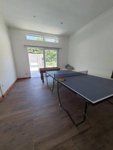 - une table de ping-pong au milieu d'une pièce dans l'établissement Casa familiar en el campo, 