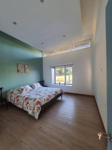 - une chambre avec un lit dans une pièce dotée d'une fenêtre dans l'établissement Casa familiar en el campo, 