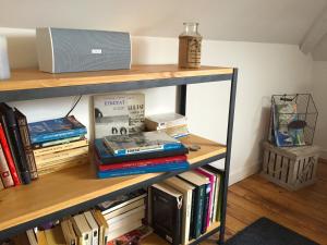 a book shelf with books and a laptop on it at Le Loft du Clocheton in Étretat