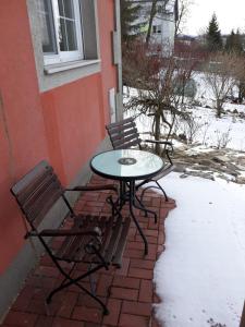 einen Tisch und zwei Stühle auf einer Backsteinterrasse in der Unterkunft Appartment Bawaria in Cieszyn