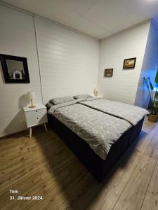 a bedroom with a large bed and a night stand at Gästhus Nornäs in Nornäs