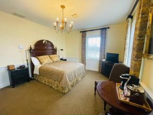 a bedroom with a bed and a desk and a chair at Excelsior at the Manor House in Clemmons