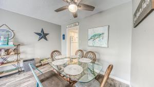 a dining room with a glass table and chairs at Southbay 34 Beach Access 3 Bedroom Townhome in Destin