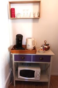 a kitchen table with a microwave and a shelf at Le Relais du Fraysse - Chambres d'hôtes in Le Fraysse