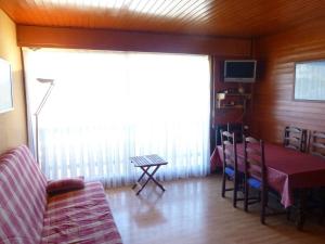 a living room with a couch and a table at Appartement Huez, 2 pièces, 6 personnes - FR-1-405-194 in LʼHuez
