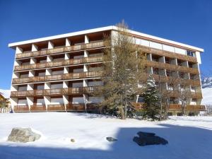 a large building with snow in front of it at Appartement Huez, 2 pièces, 6 personnes - FR-1-405-194 in LʼHuez