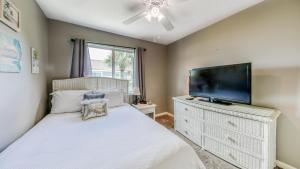 a bedroom with a bed and a flat screen tv at Southbay 34 Beach Access 3 Bedroom Townhome in Destin