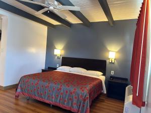 - une chambre avec un grand lit et une couverture rouge dans l'établissement Sullivan Inn, à Sullivan