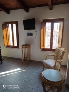 Habitación con silla, mesa y ventanas en La Tana Dell'OLMO en Fondi