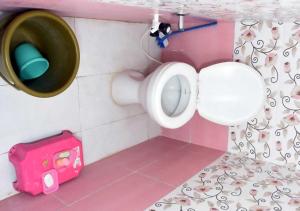 een badkamer met een urinoir en een emmer aan de muur bij SHiVAY HOMESTAY in Garudeshwar