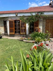 un jardín frente a una casa con flores en Habitación privada Barrio Uno en Ezeiza