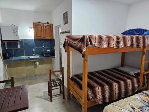 Habitación pequeña con litera y cocina en Hospedaje Los 7 Arcangeles en Termas de Río Hondo