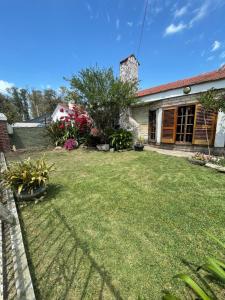 a backyard of a house with a grass yard at Habitación privada Barrio Uno in Ezeiza