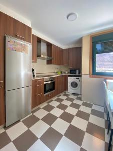 雷東德拉的住宿－A CASA DO PEREGRINO，厨房设有 ⁇ 制地板和不锈钢冰箱