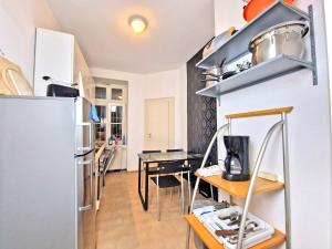 eine Küche mit einem Tisch und einem Kühlschrank in der Unterkunft * Wohnung für Monteure Zentrumsnah * WLAN * 3 Zimmer * in Leipzig