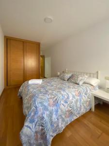 1 dormitorio con 1 cama con colcha colorida en A CASA DO PEREGRINO en Redondela
