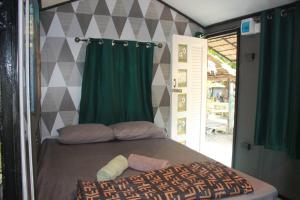 una camera con letto e tenda verde di Do Dee Cafe Bangkok Hostel a Bangkok