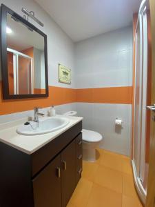 雷東德拉的住宿－A CASA DO PEREGRINO，一间带水槽、卫生间和镜子的浴室