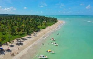 uma vista aérea de uma praia com barcos na água em Pousada, O paraíso secreto em Maragogi