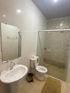 een badkamer met een wastafel, een toilet en een douche bij Pousada Véu de Noiva in São Thomé das Letras