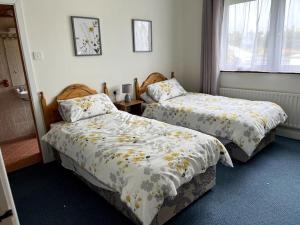 two beds sitting in a room with at Doolin Getaway. in Lisdoonvarna