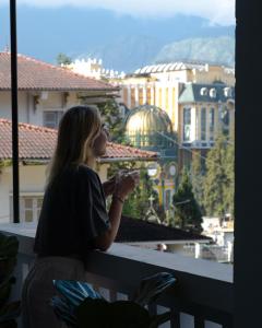 Una mujer mirando por una ventana a una ciudad en The Gate Boutique Hotel Sapa en Sa Pa